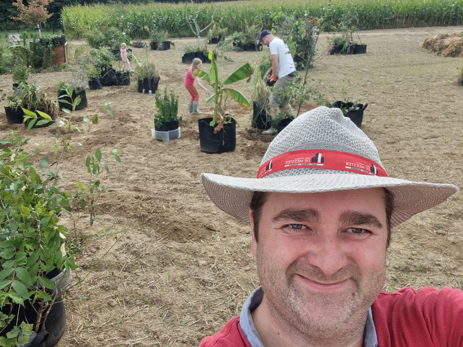 Plantwerk in volle gang tussen de potten met plantgoed