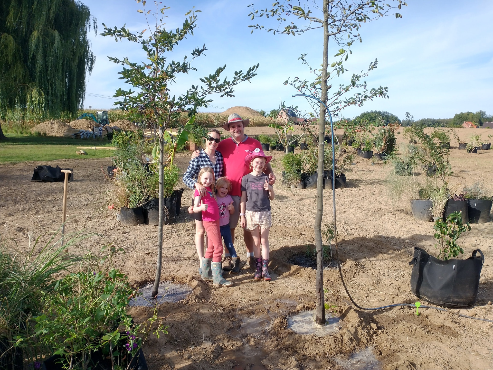 Het gezin bij de eerste geplante bomen op de testsite